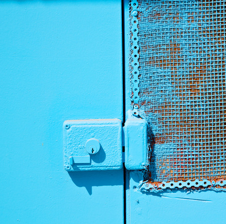 in the old wall a hinged window blue  wood and         rusty metalの写真素材