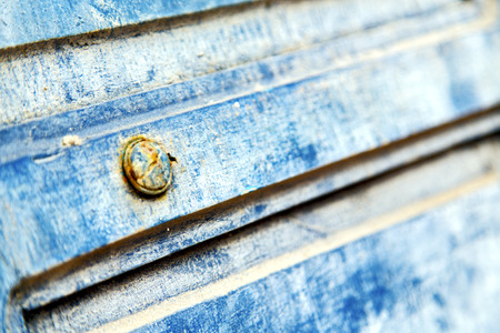 stripped paint in the blue wood door and rusty nailのeditorial素材