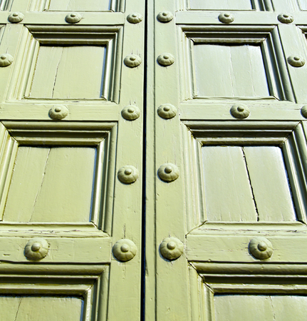 italy  patch lombardy    cross castellanza blur   abstract   rusty brass brown knocker in a  door curch  closed woodの写真素材