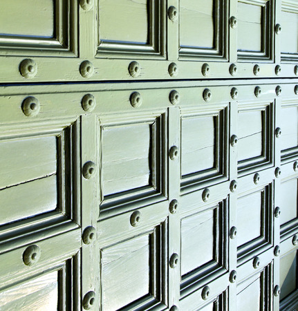 in  italy  patch lombardy    cross castellanza blur   abstract   rusty brass brown knocker  a  door curch  closed woodの写真素材