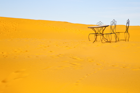 table and seat in desert sahara morocco africa yellow sandの写真素材