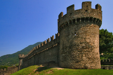 old brown castle brick and battlement in the grass of bellinzona switzerlanのeditorial素材