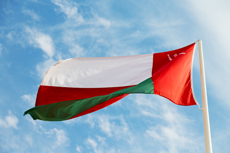 and the cloudy sky in oman waving flagの写真素材