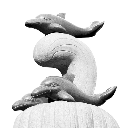 oman musact  old statue of dolphin in the sea and clear skyの写真素材