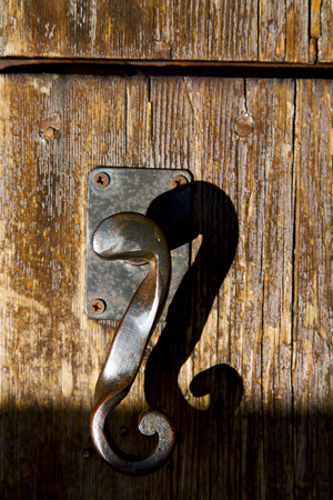 in  italy  patch lombardy    cross milan blur   abstract   rusty brass brown knocker  a  door curch  closed woodの写真素材