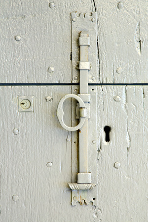 in  italy  patch lombardy    cross castellanza blur   abstract   rusty brass brown knocker  a  door curch  closed woodの写真素材