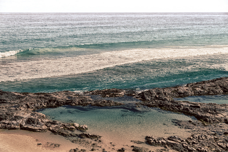 in  australia fraser island the beach near the rocks in the  wave of ocean