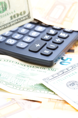 blurred calculator dollar and euro  money background like concept of differences success prosperity and businessの写真素材