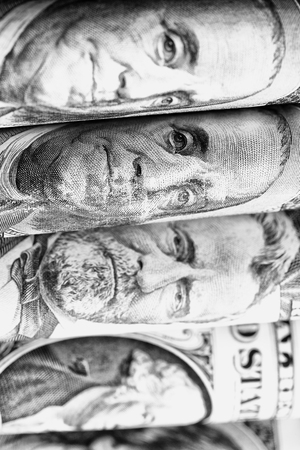 blurred dollars banknote rolled up and close up concept of economyの写真素材