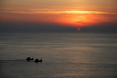 Two boat sail together at sunset, Phuket island, Thailand の写真素材