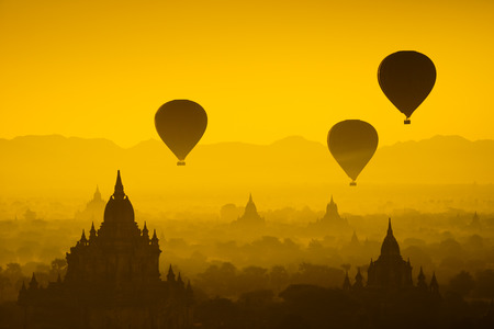 Hot air balloon over plain of Bagan in misty morning, Myanmarの写真素材