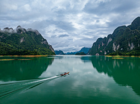 Aerial drone view of tourist boat on the lake of tropical Mountain peak , Khao Sok National Park,...