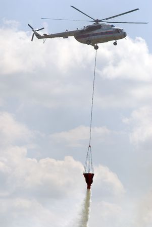 Fire helicopter releasing water from special tank