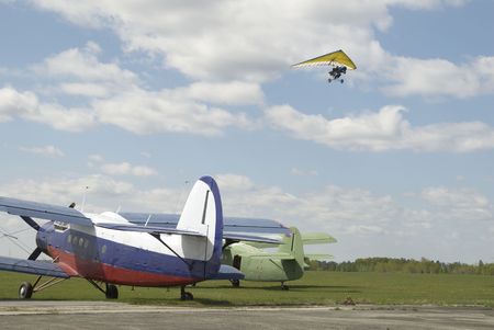 Paraglider flying over airplanes at little sport airport