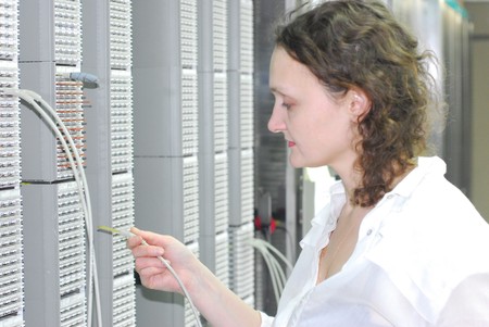 Woman working on technical site of mobile swithing center for connection cellular phones