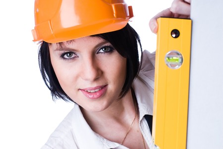 Young female worker with protection helmet and level at isolated backgroundの写真素材