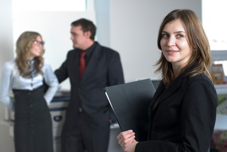Smiling business woman in office at her collegues backgroundの写真素材