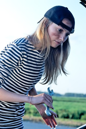 young blond woman with her broken car. The girl is angryの写真素材