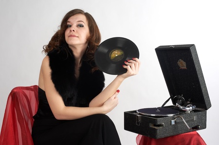 Young beautiful woman relaxing at gramophone by listening musicの写真素材
