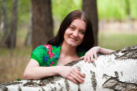 young pretty woman standing near birch in forestの写真素材