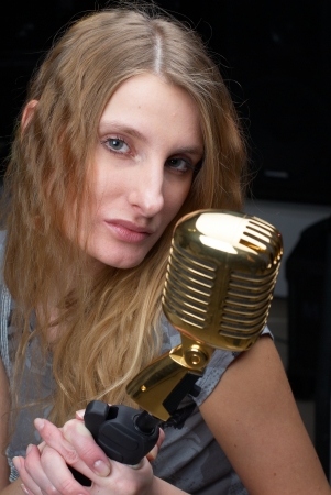 Female singer with vintage microphone at black backgroundの写真素材