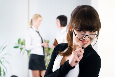 Pretty business woman in office at collegues backgroundの写真素材