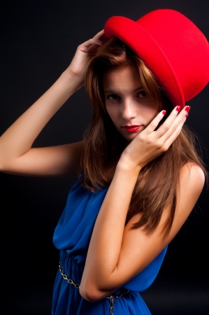 Portrait of a pretty young girl wearing hat against black backgroundの写真素材