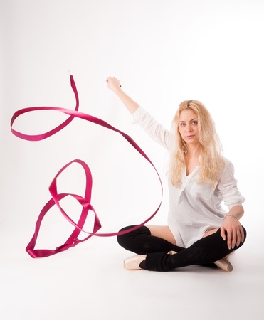 Fit young woman with red ribbon at white backgroundの写真素材