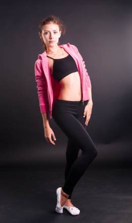 Sexy sporty woman with slim stomach over a black backgroundの写真素材