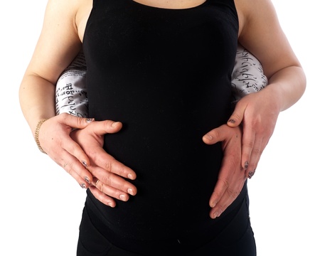 Father and mother hands on stomach of pregnant womanの写真素材