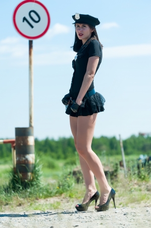 Young beautiful police woman near barrier into restricted areaの写真素材