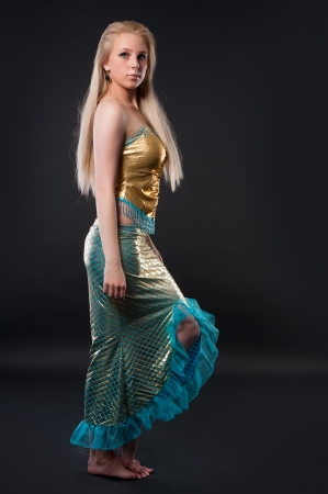 Young pretty woman in mermaid costume over black backgroundの写真素材
