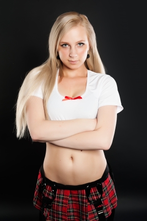 Young pretty woman in white top and red mini skirt with crossed handsの写真素材