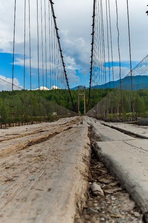 Wooden suspension road bridge on the river Katun in Tyungur  Altai Mountains, Russia の写真素材