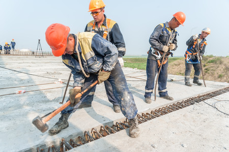 Tyumen, Russia - July 31, 2013  JSC Mostostroy-11  Bridge construction for outcome of the Tobolsk path and Bypass road round Tyumen  Workers mount bridge spanのeditorial素材