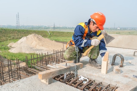 Tyumen, Russia - July 31, 2013  JSC Mostostroy-11  Bridge construction for outcome of the Tobolsk path and Bypass road round Tyumen  Worker mount bridge spanのeditorial素材