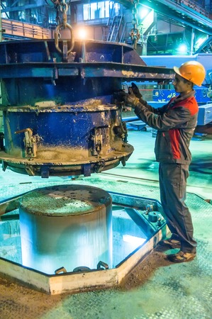 Tyumen, Russia - August 13, 2013  Circle pit making department at construction material factory ZHBI-5  Concrete Goods Plant No  5   Worker control process of making circle concrete blockのeditorial素材