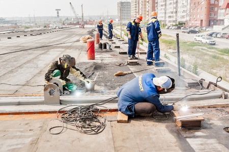 Tyumen, Russia - July 31, 2013  JSC Mostostroy-11  Bridge construction for outcome of Melnikayte street and Shirotnaya streei in Tyumen  Welders work at bridge span jointsのeditorial素材