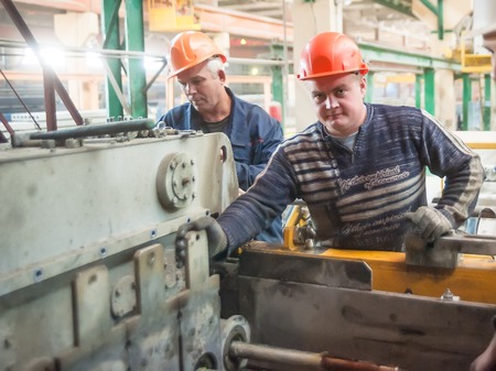 Tyumen, Russia - August 13, 2013  Block making department at construction material factory ZHBI-5    Workers set up machine in shop on production of steel concrete panelsのeditorial素材