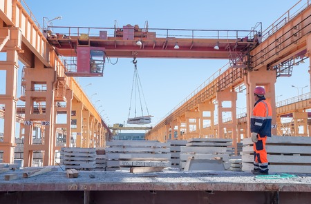Tyumen, Russia - August 13, 2013  Finished goods warehouse at Concrete Goods Plant No  5  Slinger with crane operator work at distribution of productionのeditorial素材
