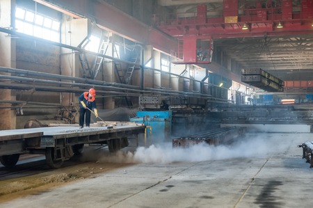 Tyumen, Russia - August 13, 2013  Finished goods warehouse at Concrete Goods Plant No  5  Worker prepares railway platform for transportation of factory productionのeditorial素材