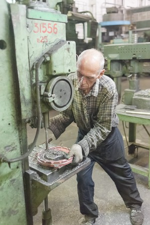 Tyumen, Russia - September 7, 2010  JSC Tyumenskie Motorostroiteli  Plant on production and repair of aviation engines   Senior worker drills bores on detail by drillerのeditorial素材