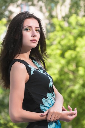 Young pretty woman posing in summer day over nature background