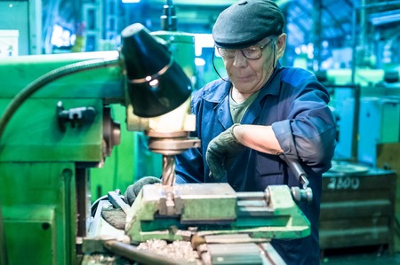 Tyumen, Russia - September 7, 2010: JSC Tyumenskie Motorostroiteli (Plant on production and repair of aviation engines). Milling-machine operator works at the machineのeditorial素材