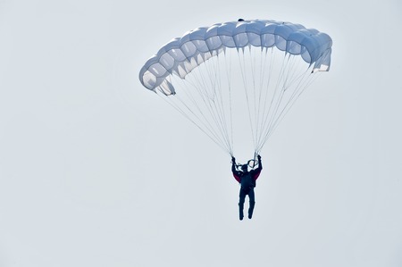 Tyumen, Russia - August 11, 2012: Air show "On a visit at UTair" in heliport Plehanovo. Paratrooper man landing in show programのeditorial素材