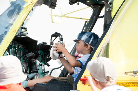Tyumen, Russia - August 11, 2012: Air show "On a visit at UTair" in heliport Plehanovo. Little boy sitting in cabin of the MI-8 helicopterのeditorial素材