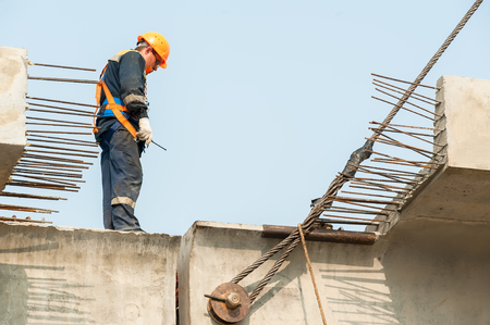 Tyumen, Russia - July 31, 2013: JSC Mostostroy-11. Bridge construction for outcome of the Tobolsk path and Bypass road round Tyumen. Builder Worker in safety protective equipment on bridge constructionのeditorial素材