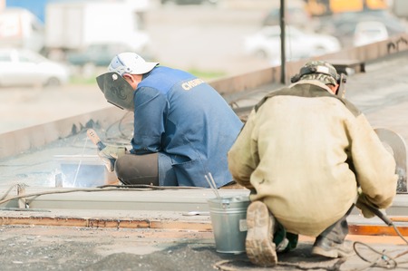 Tyumen, Russia - July 31, 2013: JSC Mostostroy-11. Bridge construction for outcome of Melnikayte street and Shirotnaya streei in Tyumen. Welders in action with bright sparksのeditorial素材