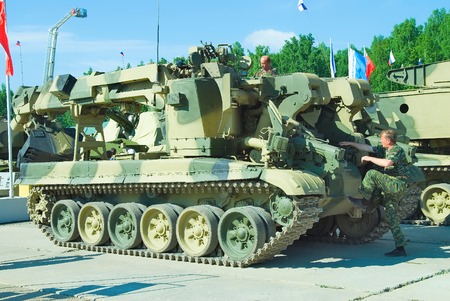 Nizhniy Tagil, Russia - July 12. 2008: Visitors explore military equipment on exhibition range. Crew of ?ombat engineering vehicle IMR-2MA prepares to motionのeditorial素材