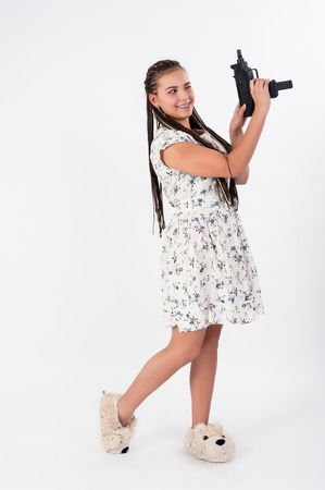 Young beautiful smiling woman with african braids aiming in target from gunの写真素材